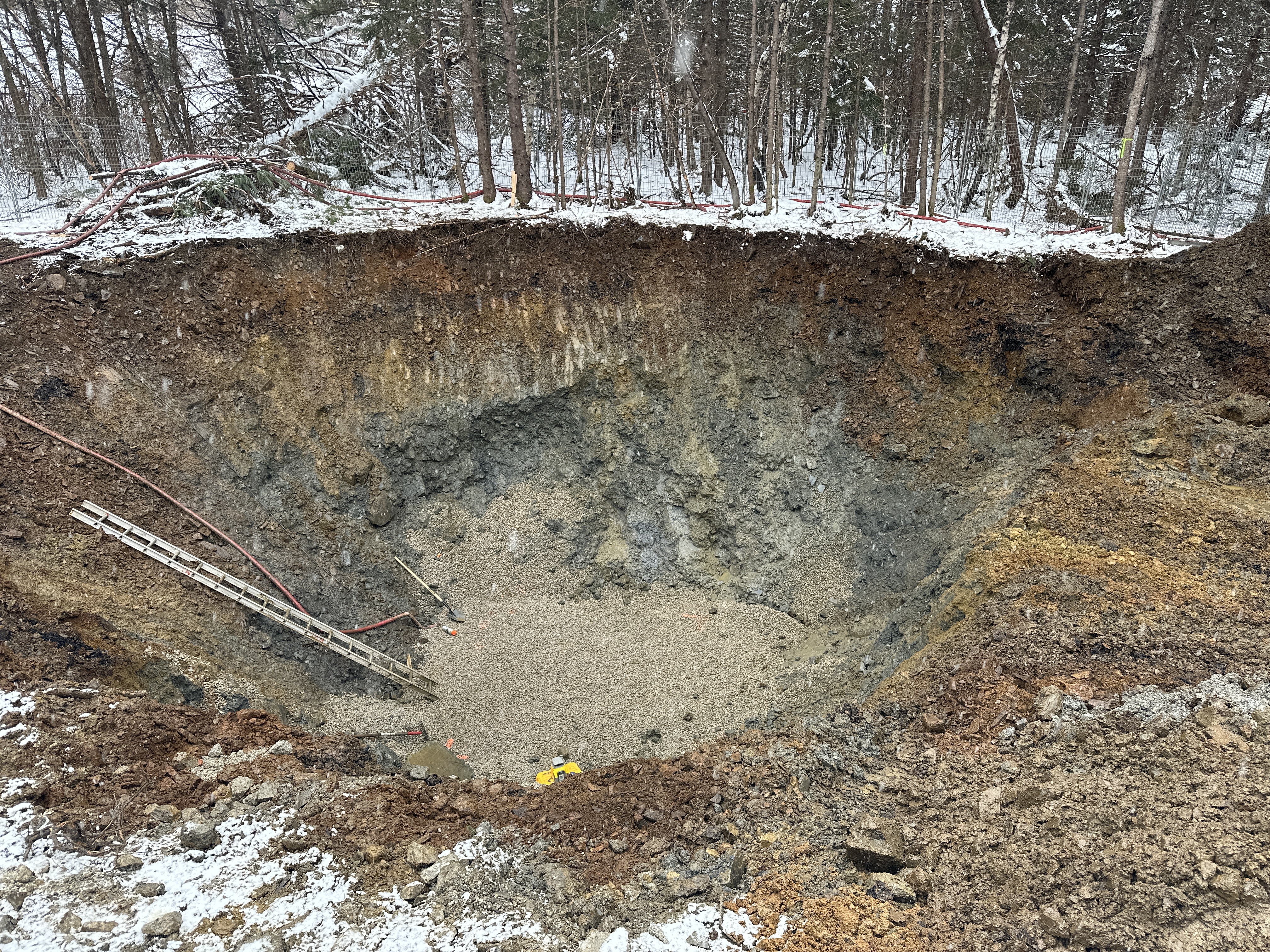 large construction hole with a ladder to get in and out