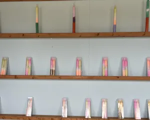 Colourful tapered dip dye candles on shelves