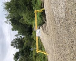 Barricade with a Trail Closed Sign by a washed out section on the trail.